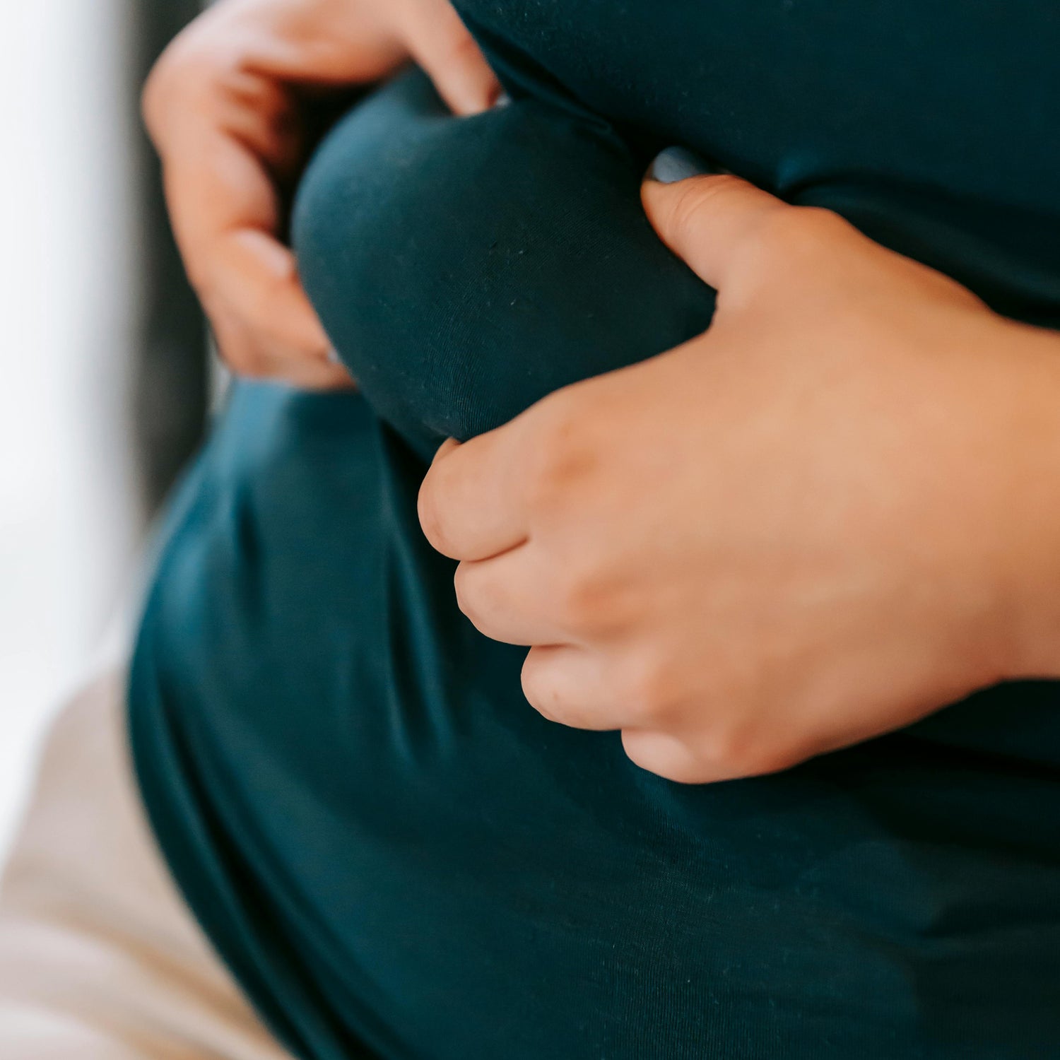 Das Bild zeigt eine Person, die sich nachdenklich an den Bauch fasst, ein Symbol für die Beschäftigung mit dem eigenen Übergewicht und dem Wunsch nach Veränderung