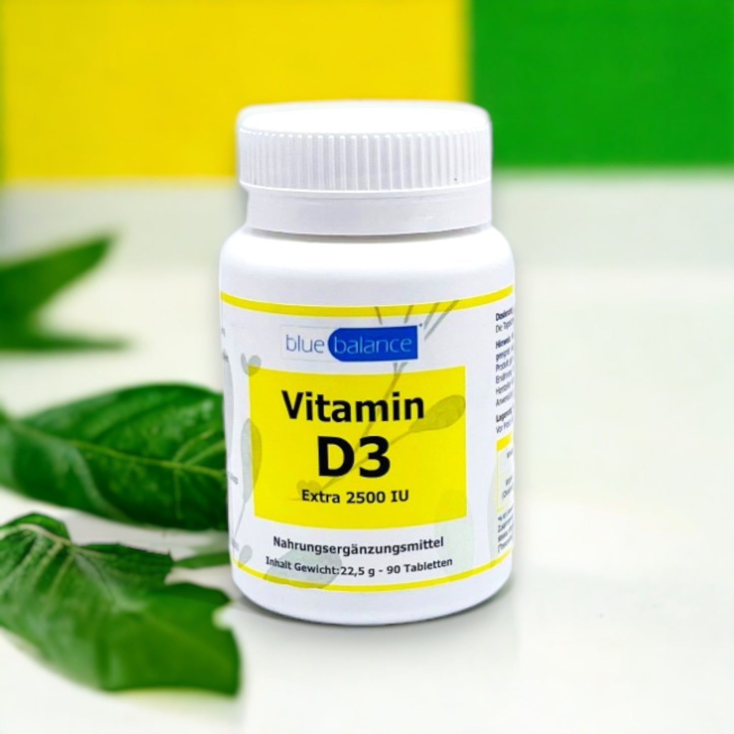 Vitamin D3-Tablettendose von Blue Balance ETH Meditec arrangiert in einem minimalistischen weißen Raum, akzentuiert durch frische grüne Blätter neben der Dose, was Natürlichkeit und Gesundheit symbolisiert.